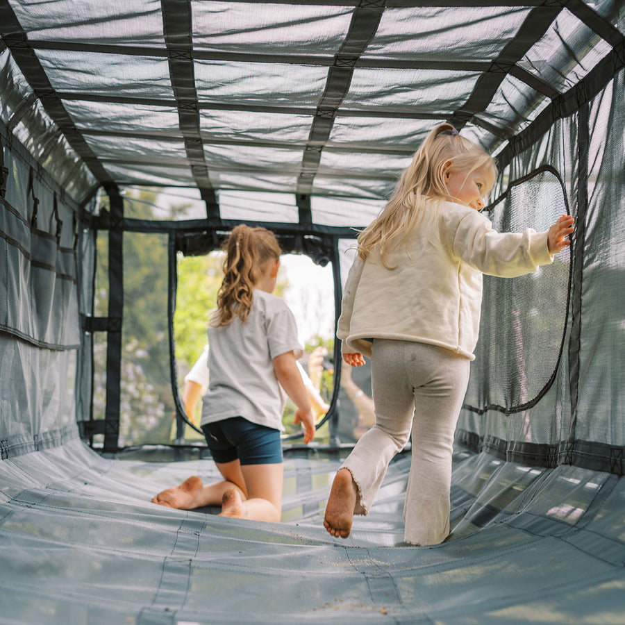 Children inside black Cubby Clubhouse on Funky Monkey Bars frame