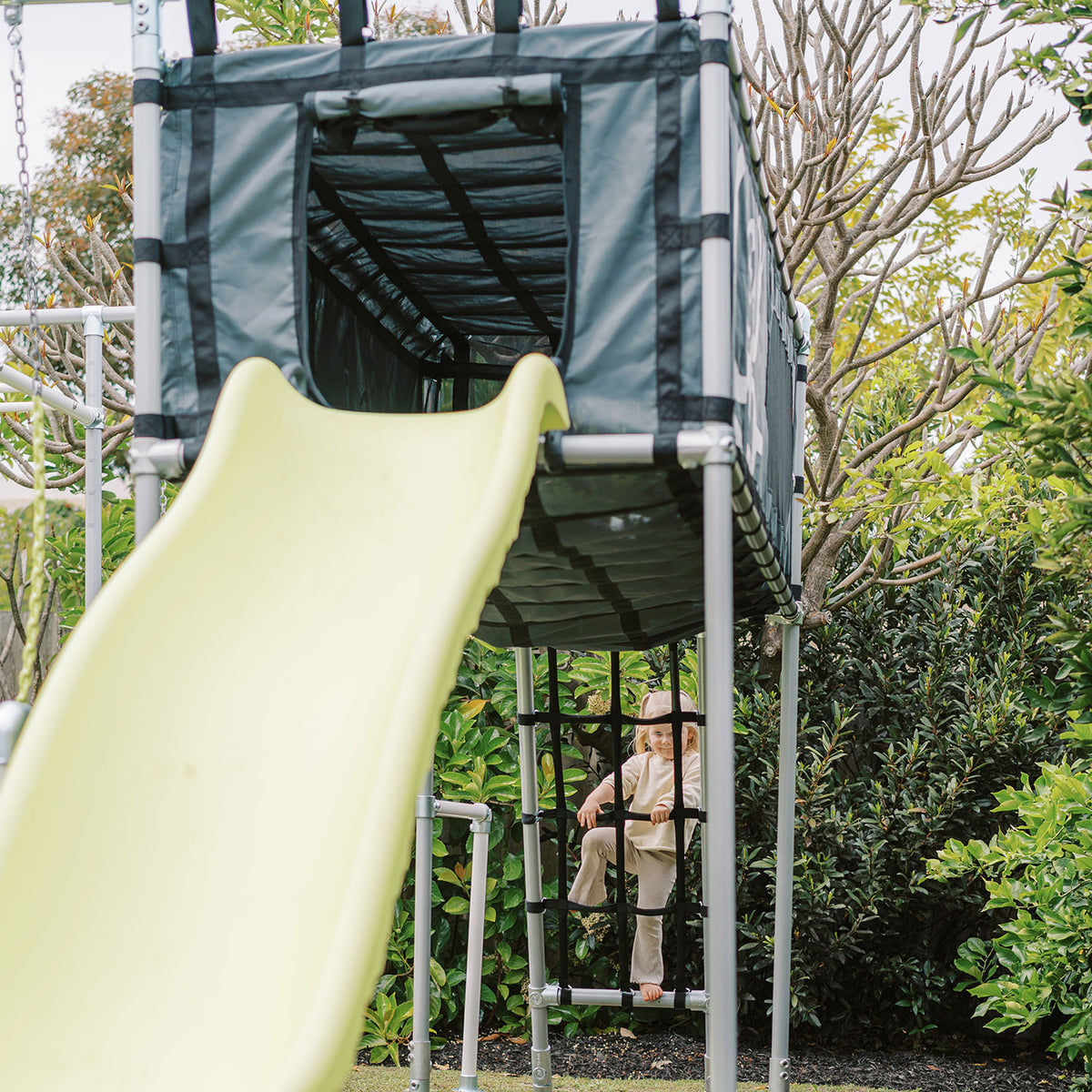 Yellow slide attached to black Cubby Clubhouse on Funky Monkey Bars frame